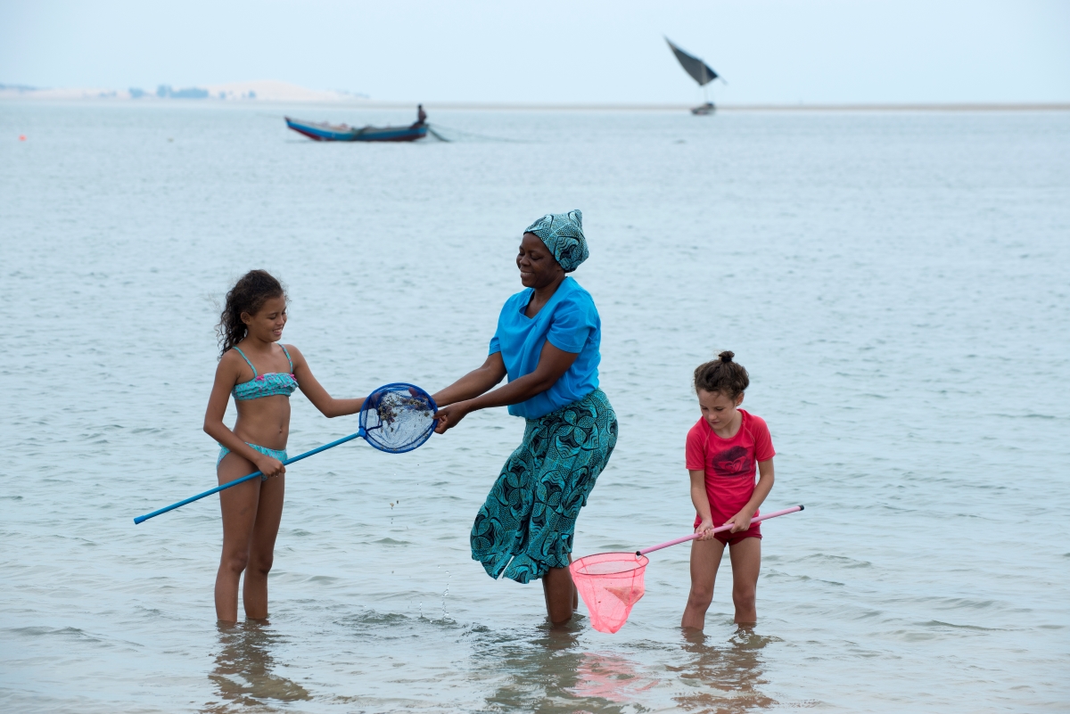 andBeyond-Benguerra-Island-ocean-activities Local woman helping children catch sea creatures in the shallows